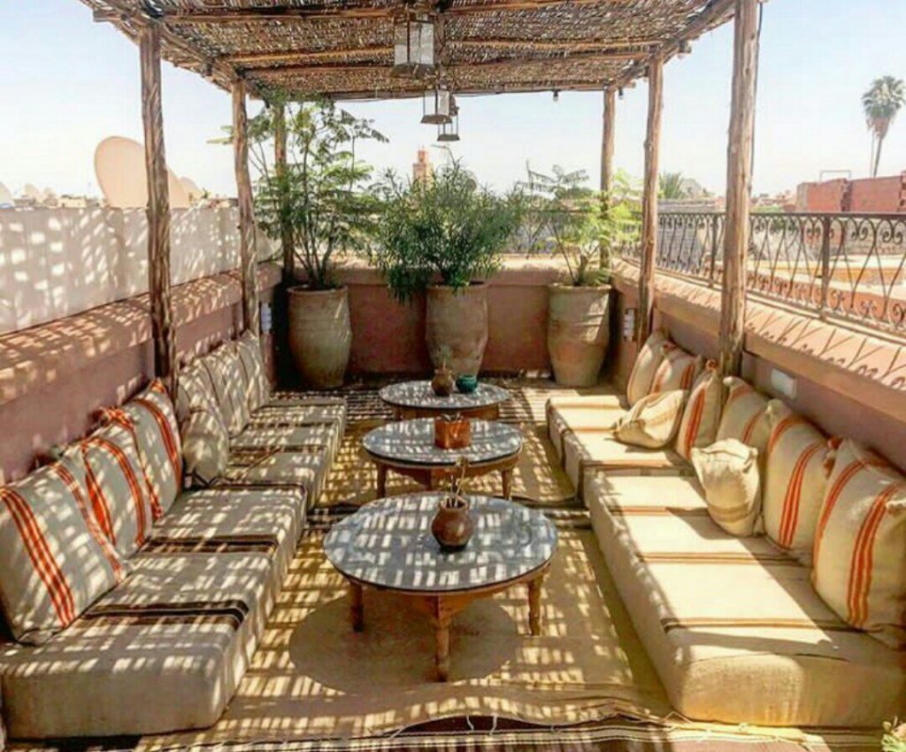 rooftop di un riad marocchino con cuscini a terra e piante grasse