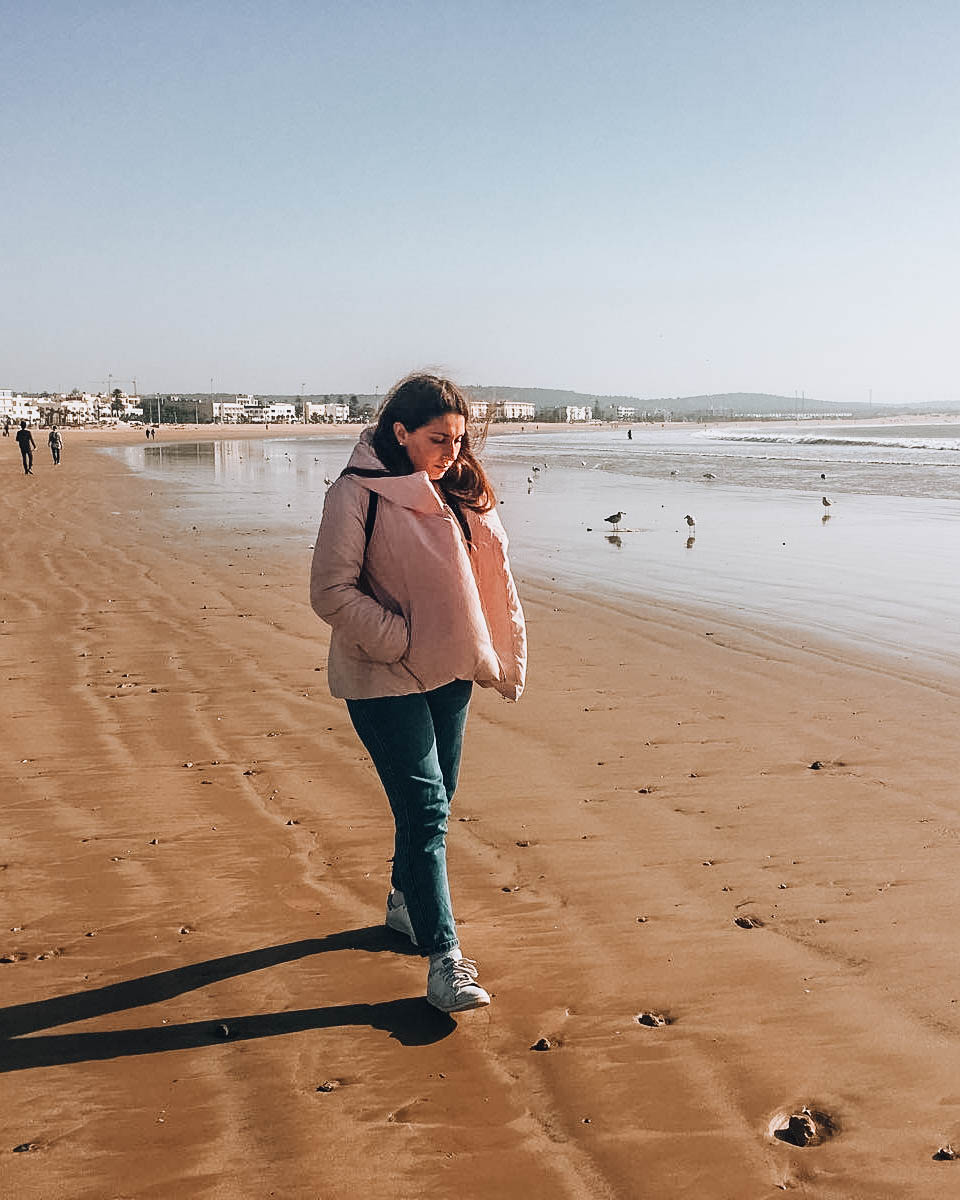 ragazza che cammina su spiaggia d'inverno