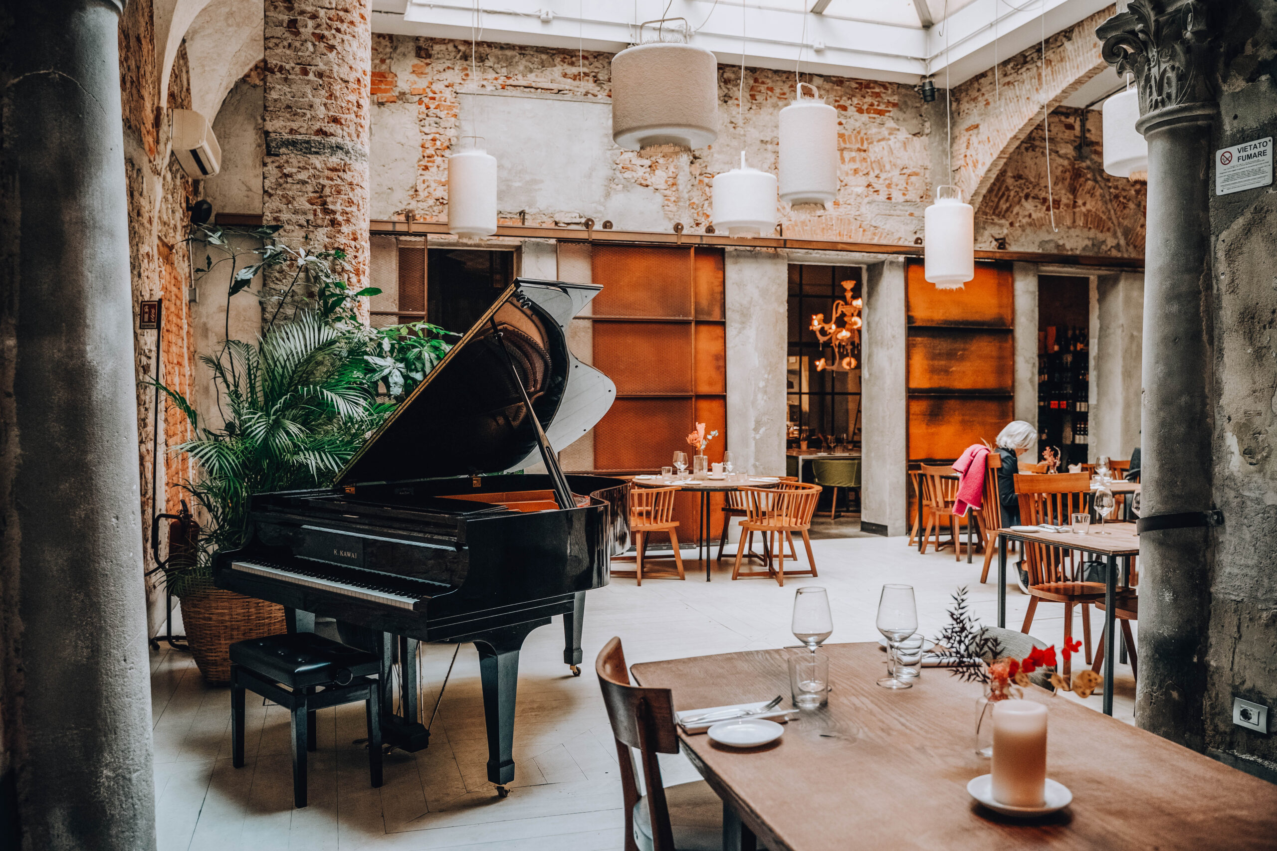 interno di bistrot per fare un brunch a Firenze con tavoli in legno e pianoforte