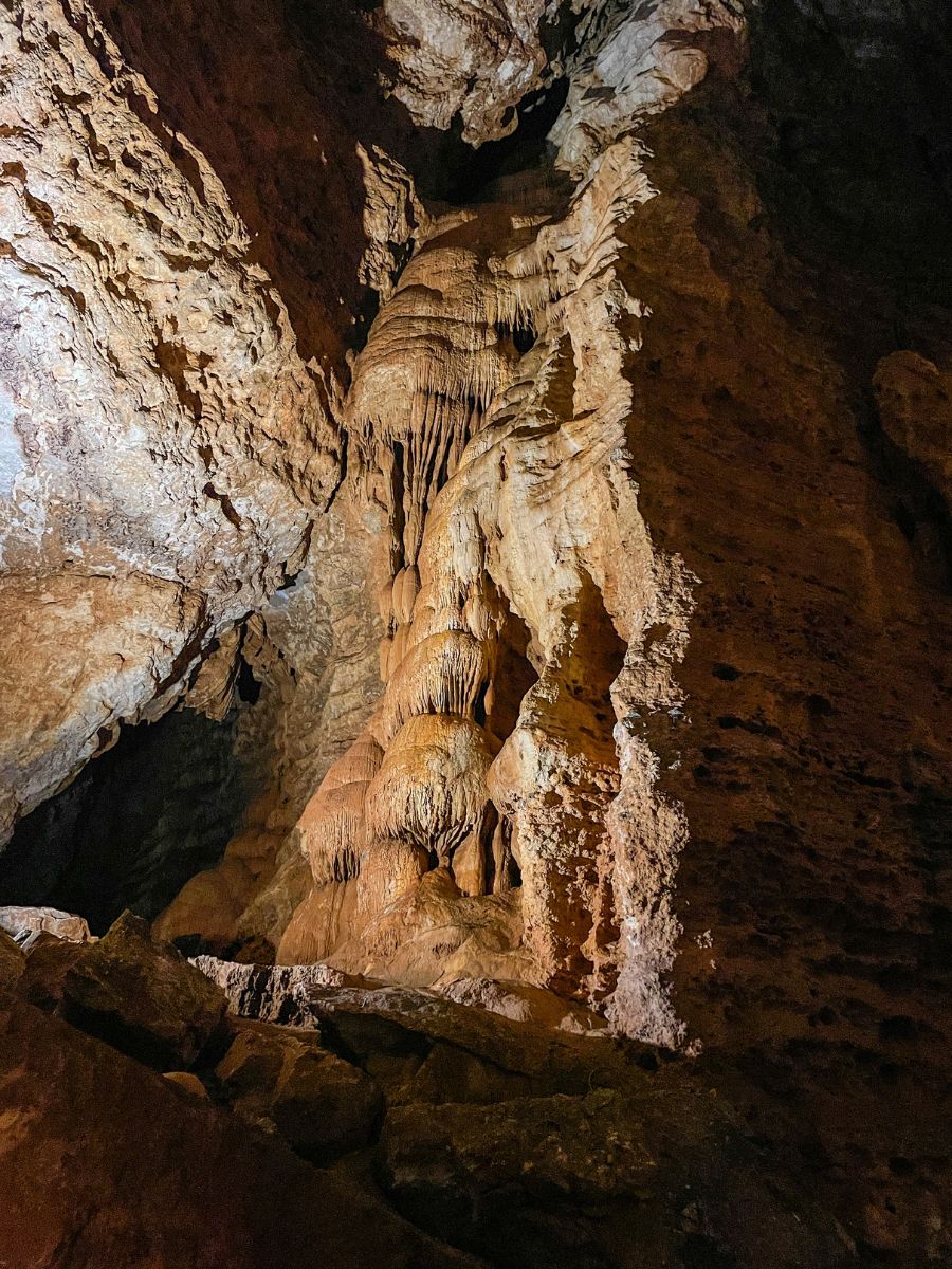 Una monumentale colonna di stalagmiti, formata dall'unione di stalattiti e stalagmiti, si erge all'interno delle Grotte di Su Marmuri, mostrando le incredibili sculture naturali da vedere a Ulassai.